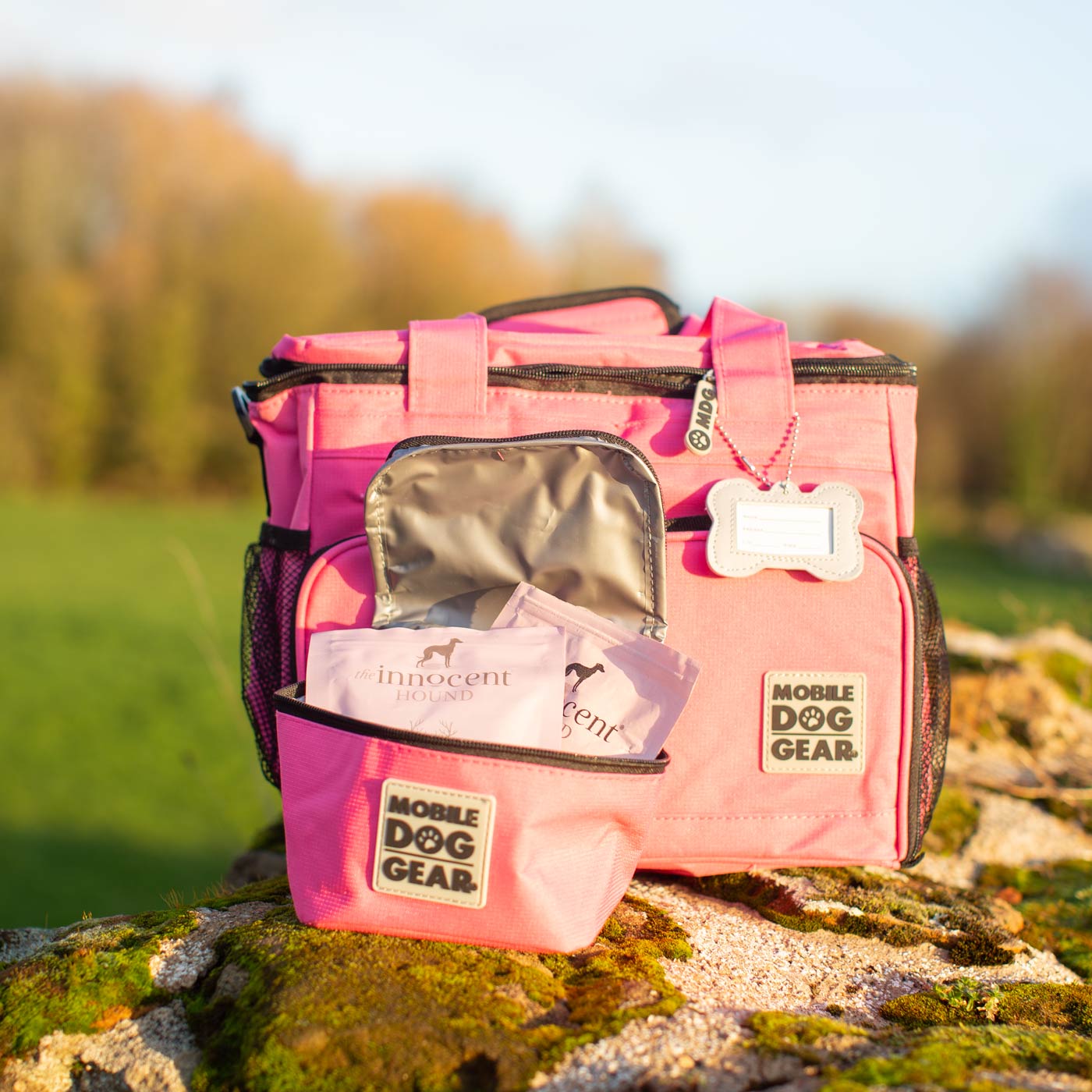 Discover, Mobile Dog Gear Week Away Bag, in Pink. The Perfect Away Bag for any Pet Parent, Featuring dividers to stack food and built in waste bag dispenser. Also Included feeding set, collapsible silicone bowls and placemat! The Perfect Gift For travel, meets airline requirements. Available Now at Lords & Labradors US