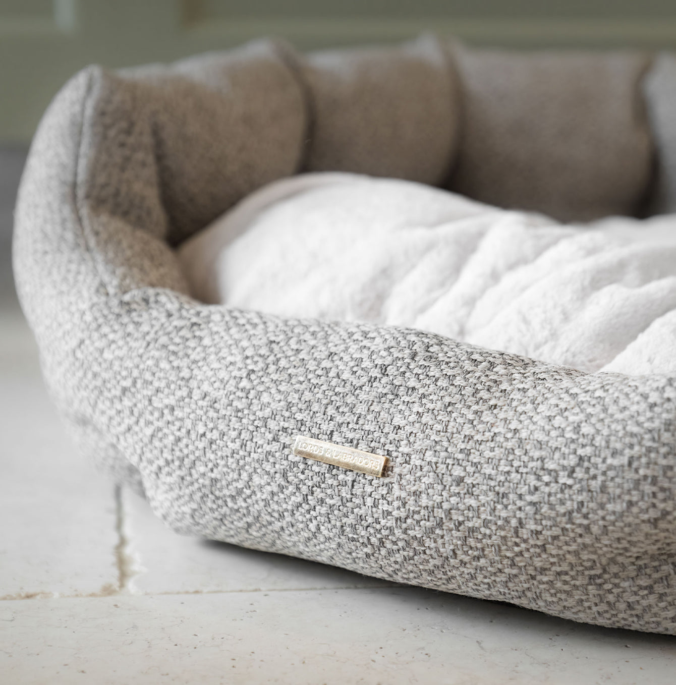 Discover our luxury Herdwick oval dog bed in beautiful pebble, the ideal choice for dogs to enjoy blissful nap-time, featuring reversible inner cushion with raised sides for dogs who love to rest their head for the ultimate cosiness! Handcrafted in Italy for pure pet luxury! Available now at Lords & Labradors US